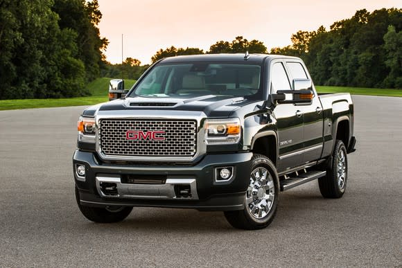 A black 2017 GMC Sierra 2500 Denali HD, parked near a wooded area.