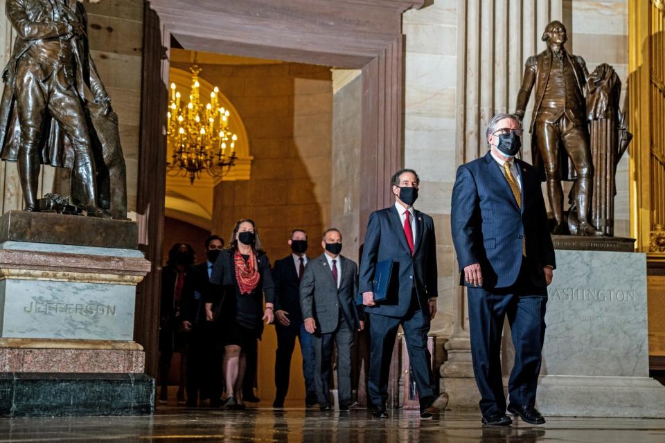 House impeachment managers walk through the U.S. Capitol rotunda.