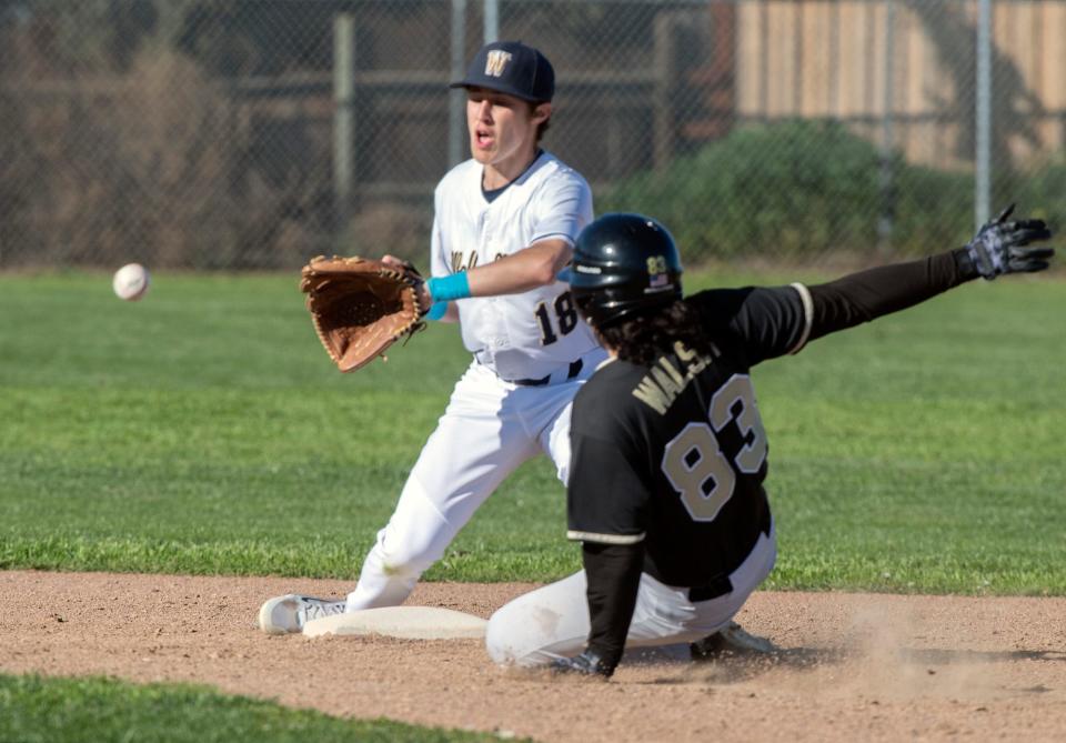 West's Tyler Armstrong, left, waits for the throw as Millennium's Patrick Walsh slides safely at second during a varsity baseball game at West High In Tracy.