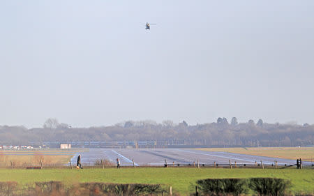 FILE PHOTO: A police helicopter flies over the closed runway at Gatwick Airport after drones flying illegally over the airfield forced the closure of the airport, in Gatwick, Britain, December 20, 2018. REUTERS/Peter Nicholls
