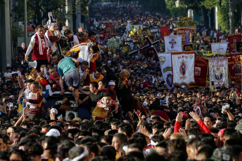 Filipino devotees attempt to climb and touch the Black Nazarene during the annual procession celebrating its feast day in Manila