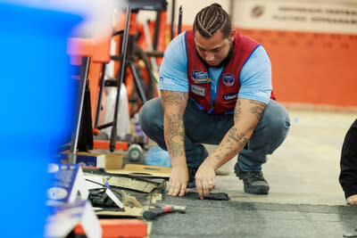 Lowe's associate helps to install a floor at a 2023 Lowe's Hometowns project in Greensboro, North Carolina.