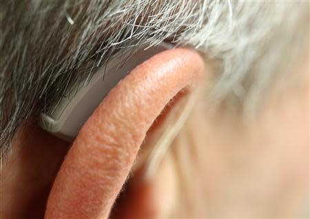 An employee of GN, the world's fourth largest maker of hearing aids, demonstrates the use of ReSound LiNX in Vienna November 22, 2013. REUTERS/Heinz-Peter Bader