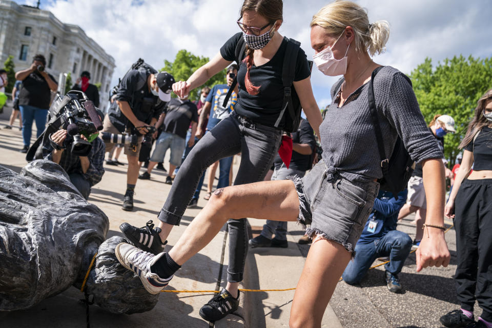 People take turns stomping the Christopher Columbus statue after it was toppled in front of the Minnesota State Capitol in St. Paul, Minn., on Wednesday, June 10, 2020. (Leila Navidi/Star Tribune via AP)