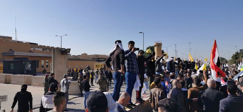 Manifestantes y milicianos se reúnen para condenar los ataques aéreos a las bases pertenecientes a Hashd al-Shaabi (fuerzas paramilitares), frente a la puerta principal de la embajada de Estados Unidos en Bagdad, Irak, el 31 de diciembre de 2019