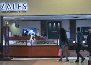Shoppers gaze into a Zales jewelry store as they walk past the store inside the Kings Plaza Mall, Tuesday Oct. 20, 2020, in New York. The coronavirus pandemic is transforming holiday hiring this year, with companies starting hiring earlier and offering extra safety protocols. Zales and Jared, plans to hire 4,000 holiday workers. (AP Photo/Bebeto Matthews)