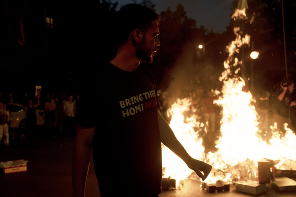 A supporter of Israeli-American hostage Hersh Goldberg-Polin, who was kidnapped on Oct. 7, 2023, walks near a bonfire lit in protest outside of Israeli Prime Minister Benjamin Netanyahu's residence to demand a deal for the immediate release of all hostages, after Hamas released a video of Goldberg-Polin, in Jerusalem, Wednesday, April 24, 2024. (AP Photo/Maya Alleruzzo)