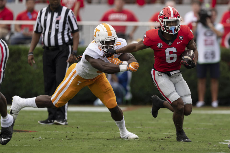 Georgia running back Kenny McIntosh, right, fends off Tennessee defensive lineman Byron Young during the first half of an NCAA college football game Saturday, Nov. 5, 2022 in Athens, Ga. (AP Photo/John Bazemore)