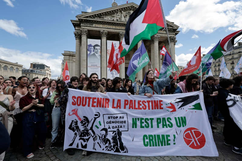 People wave Palestinian flags during an action by students from several universities in support of the Palestinian people. Police broke up a sit-in by pro-Palestinian students at the prestigious Sciences Po University in Paris. Stephane De Sakutin/AFP/dpa