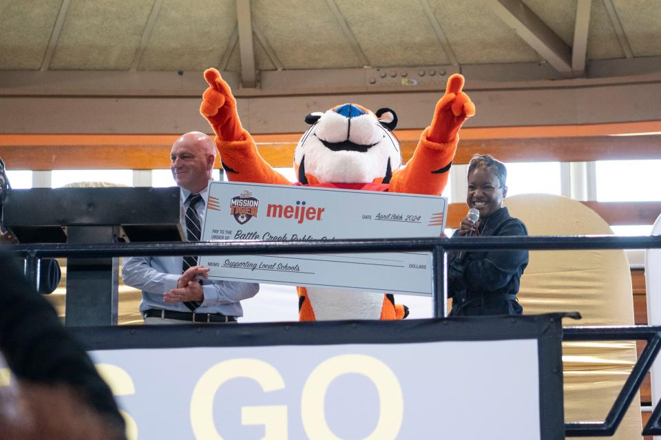 Battle Creek Public Schools athletic director Lorin Granger, Tony the Tiger and superintendent Kimberly Carter accept a check for $50,000 from the Mission Tiger initiative at Springfield Middle School on Thursday, April 18, 2024.