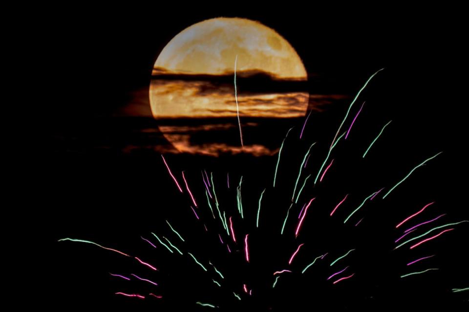 La superluna del ciervo asciende entre fuegos artificiales el lunes 3 de julio 2023, en Kansas City, EEUU (The Associated Press)