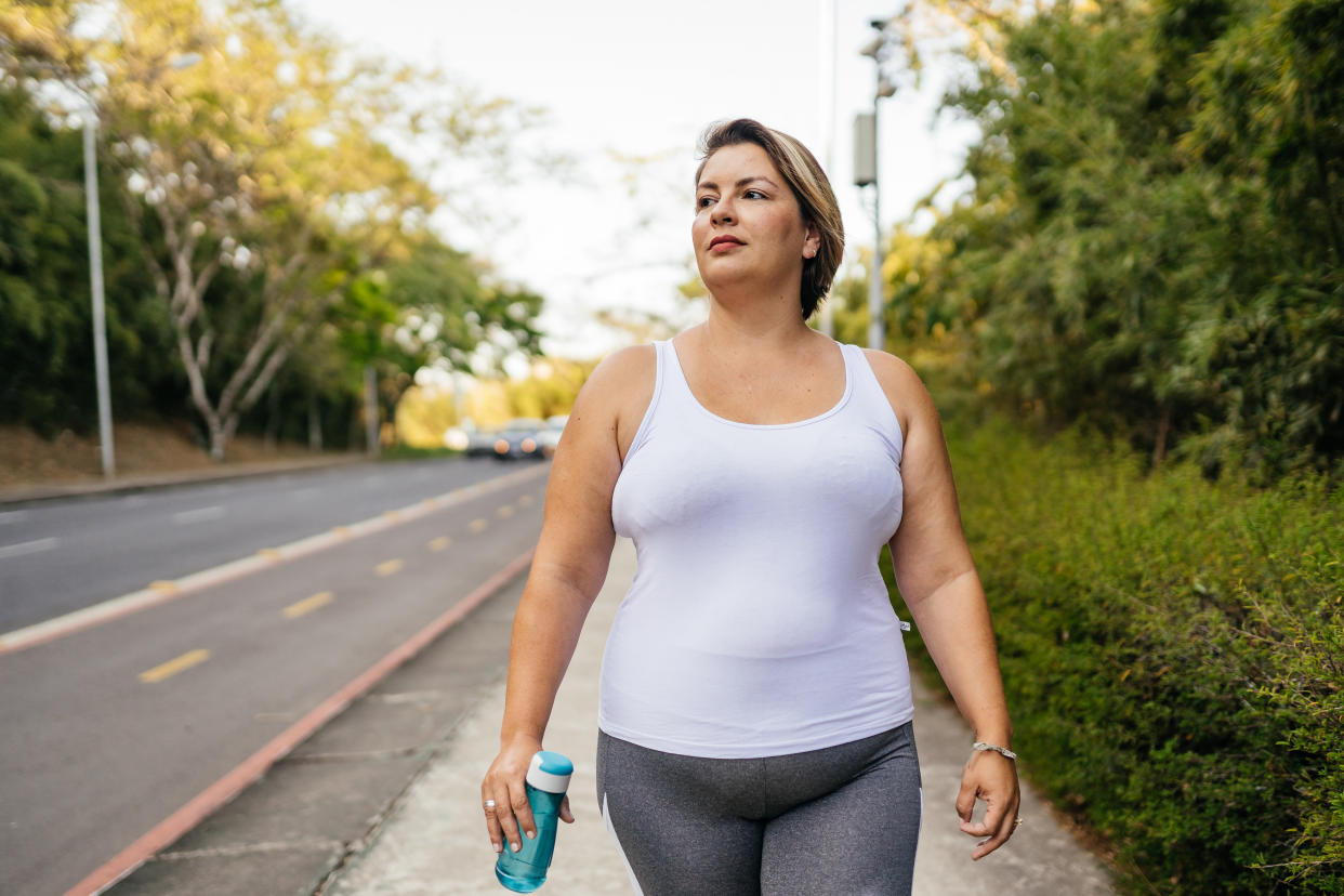 Woman walking in workout clothes with water bottle