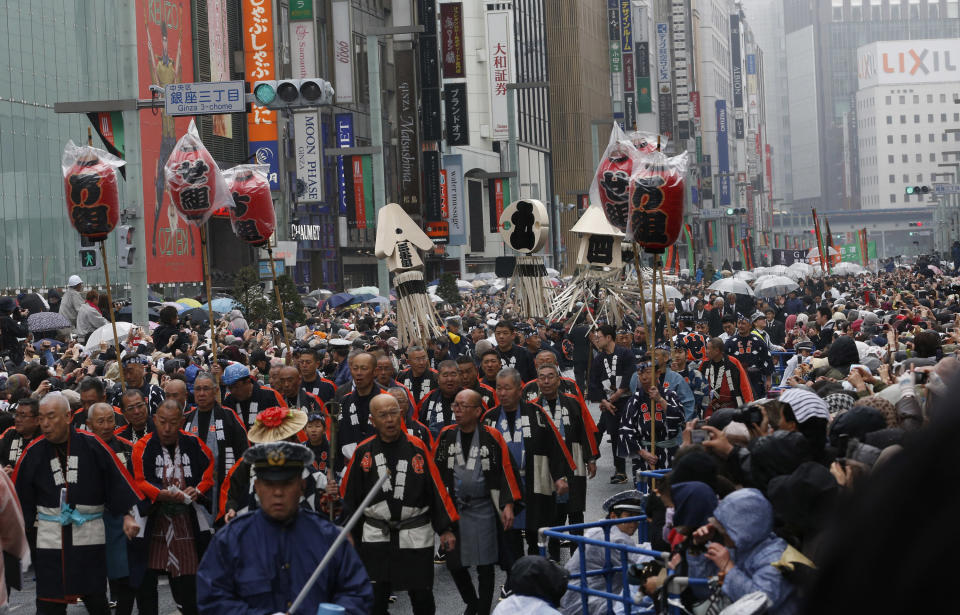 Members of a traditional firefighting preservation group along with Kabuki actors parade at Ginza shopping district in Tokyo, Wednesday, March 27, 2013. Some 60 actors paraded in the rain Wednesday to newly renovated Tokyo theatre ahead of its official opening. (AP Photo/Shizuo Kambayashi)