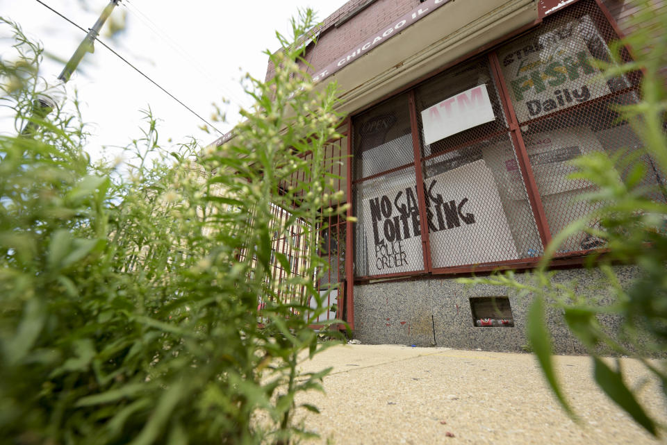 The shuttered and locked up J&J Meats has a "No Gang Loitering, Police Order" sign set up behind the cage over the windows at 79th and Escanaba Avenue in Chicago on Friday, Aug. 13, 2021, in a neighborhood on the South Side near where the shooting of Safarian Herring took place. (AP Photo/Mark Black)