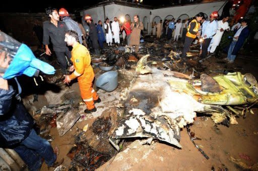 Pakistani rescue workers and local residents search the site of a plane crash in Rawalpindi. The Bhoja Air flight from Karachi burst into flames after coming down in fields near a village on the outskirts of the Pakistani capital as it tried to land in rain and hail at the city's international airport