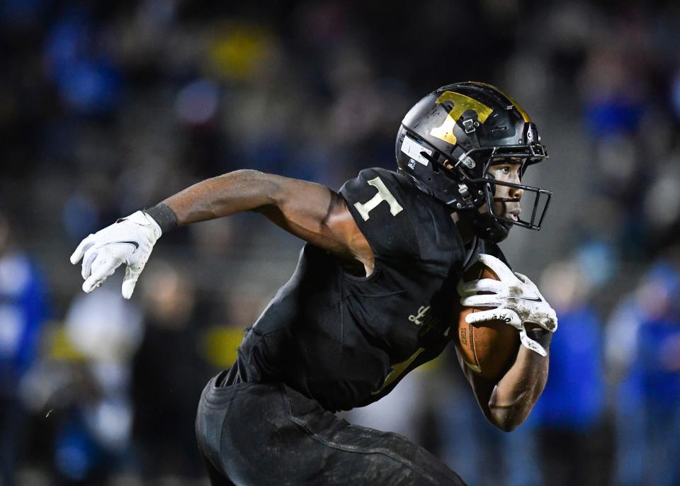 Treasure Coast's Eden James gains yardage against Apopka in a high school football 8A state semifinal on Friday, Dec. 3, 2021, at South County Regional Stadium in Port St. Lucie. The Titans lost 21-0.
