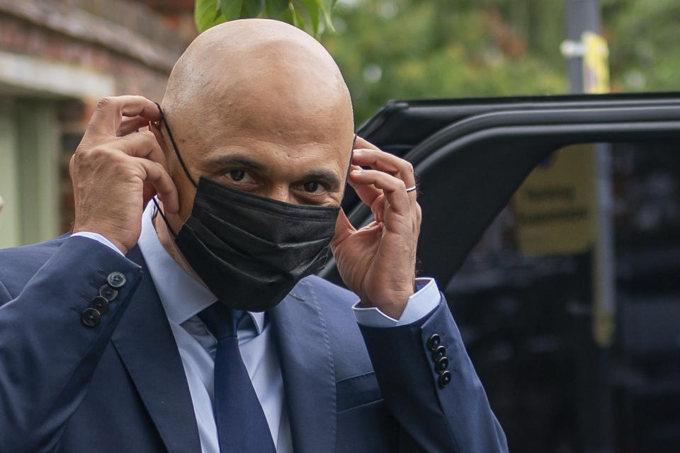 Former Chancellor of the Exchequer Sajid Javid puts on a face mask to get into a vehicle, after he was appointed as Secretary of State for Health and Social Care, following the resignation of Matt Hancock, in London, Sunday June 27, 2021. Hancock resigned a day after apologizing for breaching social distancing rules with an aide with whom he was allegedly having an affair. (Aaron Chown/PA via AP)