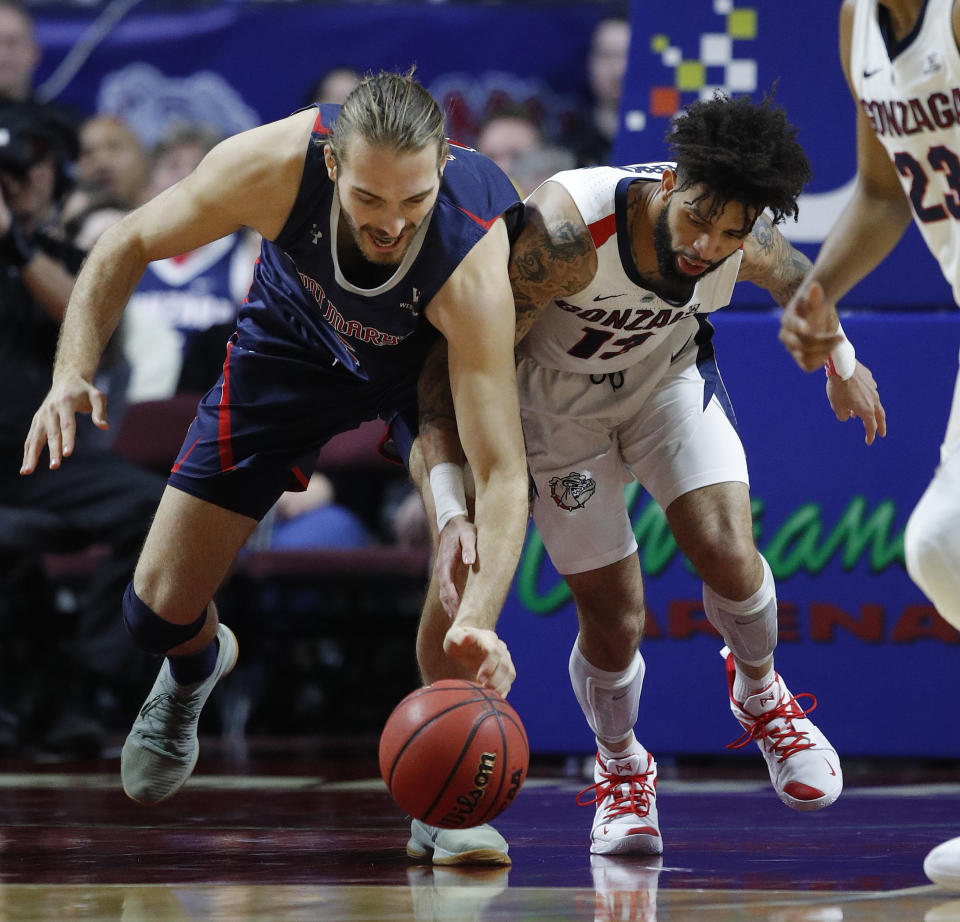 St. Mary's Jock Perry, left, and Gonzaga's Josh Perkins scramble for the ball during the first half of an NCAA college basketball game for the West Coast Conference men's tournament title, Tuesday, March 12, 2019, in Las Vegas. (AP Photo/John Locher)