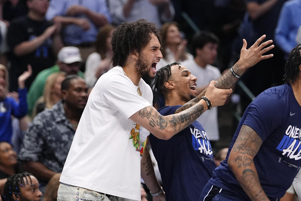 Injured Dallas Mavericks center Dereck Lively II, left, reacts to a play during the second half in Game 4 of the NBA basketball Western Conference finals against the Minnesota Timberwolves, Tuesday, May 28, 2024, in Dallas. (AP Photo/Julio Cortez)