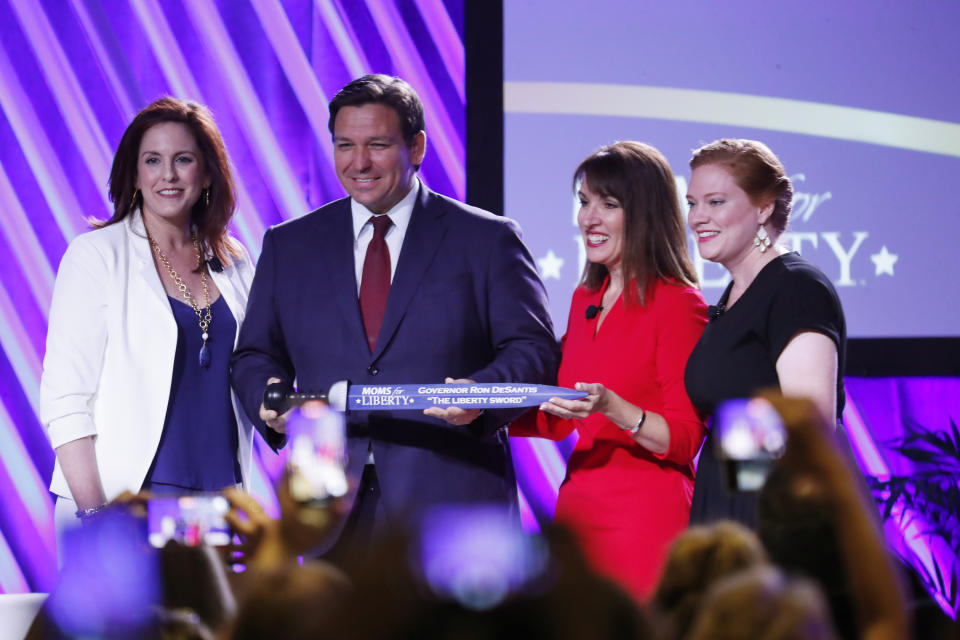 Moms for Liberty co-founders Tiffany Justice and Tina Descovich present the Liberty Sword to Florida Gov. Ron DeSantis.