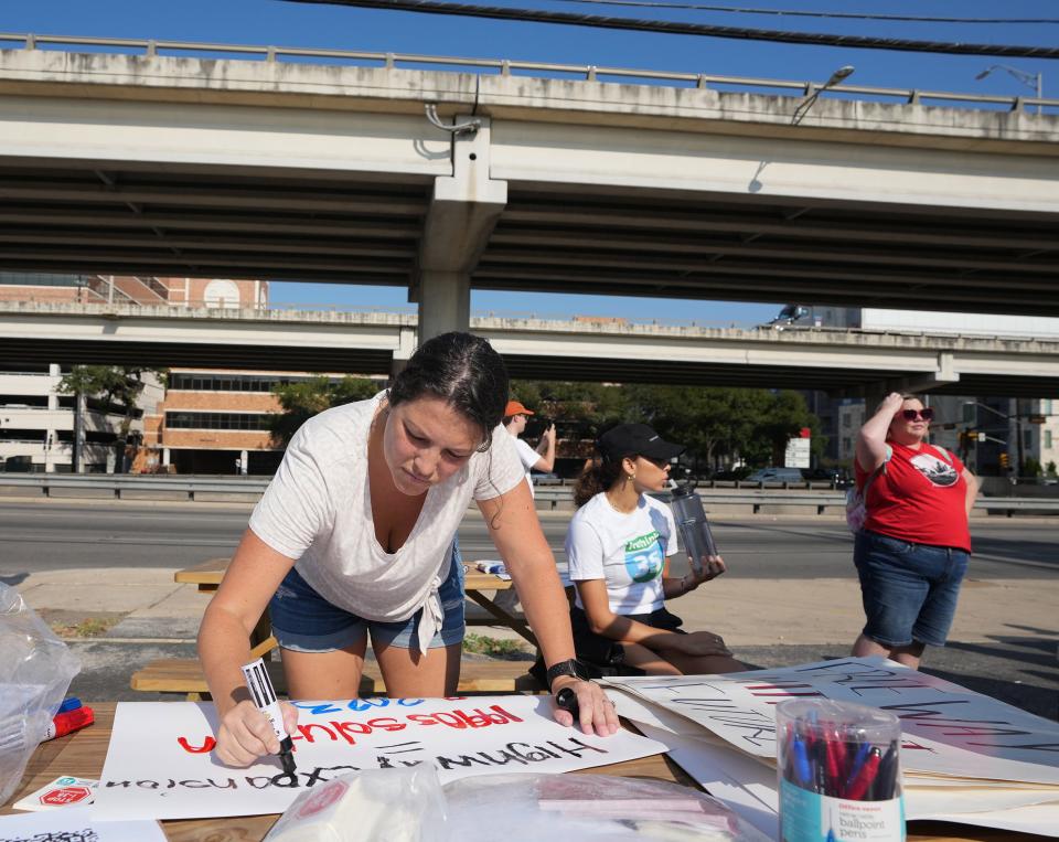 Angela Desantis makes a sign at a protest against the I-35 expansion plans at Stars Cafe, which sits right next to the highway in the Cherrywood neighborhood, on Wednesday August 30, 2023.
