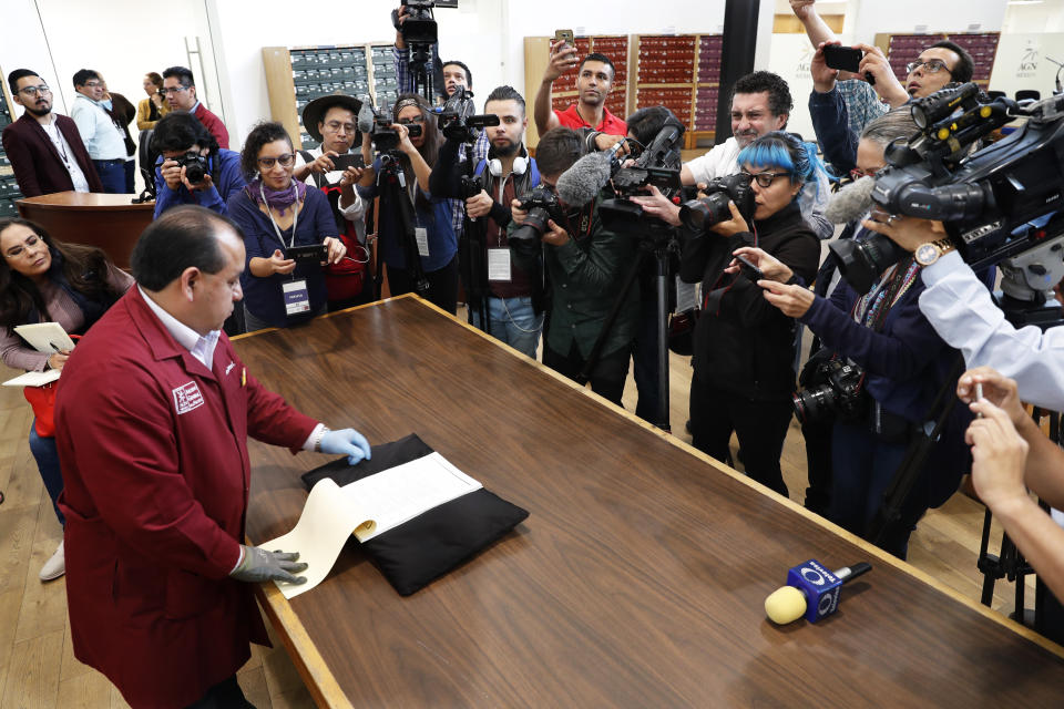 A National Archive employees shows old intelligence documents drawn up by spies in 1979 and 1980 from the now-extinct Federal Security Department, at a media presentation in Mexico City, Tuesday, April 16, 2019. Mexico's domestic intelligence agency was once so paranoid it even spied on members of the former ruling party. One such member was current President Andres Manuel López Obrador, who previously belonged to the Institutional Revolutionary Party. (AP Photo/Marco Ugarte)