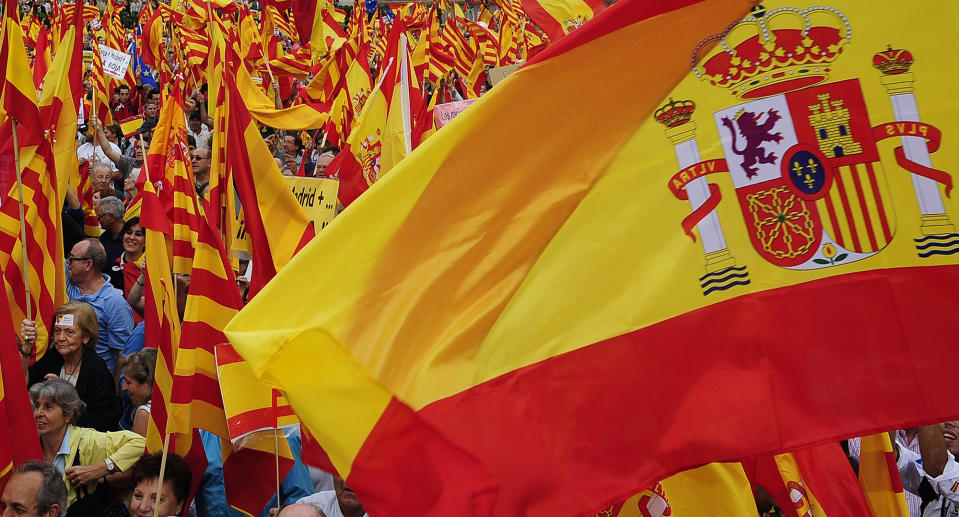 People opposed to the independence of Catalonia hold Catalan and Spanish flags during the holiday known as Dia de la Hispanidad, Spain's National Day in Barcelona, Spain, Friday, Oct. 12, 2012. Spain is observing its National Day festivities in somber mood as the traditional military pageant was scaled back to cut costs. Spain is in recession and under pressure to fix its finances while celebrating the day Christopher Columbus discovered America in the name of the Spanish Crown. (AP Photo/Manu Fernandez)