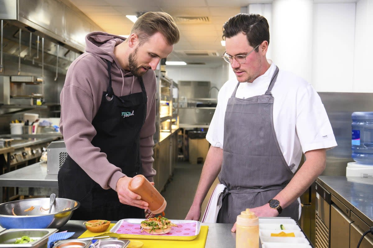 EDITORIAL USE ONLY England captain Harry Kane prepares a limited-edition burger called ‘The Record Breaker’ at TOCA Social at The O2, London, which has been created using his favourite ingredients to celebrate him becoming England’s all-time record goal scorer, following his goal against Italy last Thursday. Issue date: Tuesday March 28, 2023. (PA Wire)