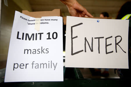 People pick up free dust masks in Keaau to protect themselves from volcanic ash during ongoing eruptions of the Kilauea Volcano in Hawaii, U.S., May 17, 2018. REUTERS/Terray Sylvester