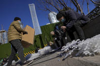 Workers wearing face masks install snowflake-shaped lights near the Central Business District in Beijing, Monday, Jan. 17, 2022. China’s economy expanded by 8.1% in 2021 but Beijing faces pressure to shore up activity after an abrupt slump in the second half as the ruling Communist Party forced its vast real estate industry to cut surging debt. (AP Photo/Andy Wong)