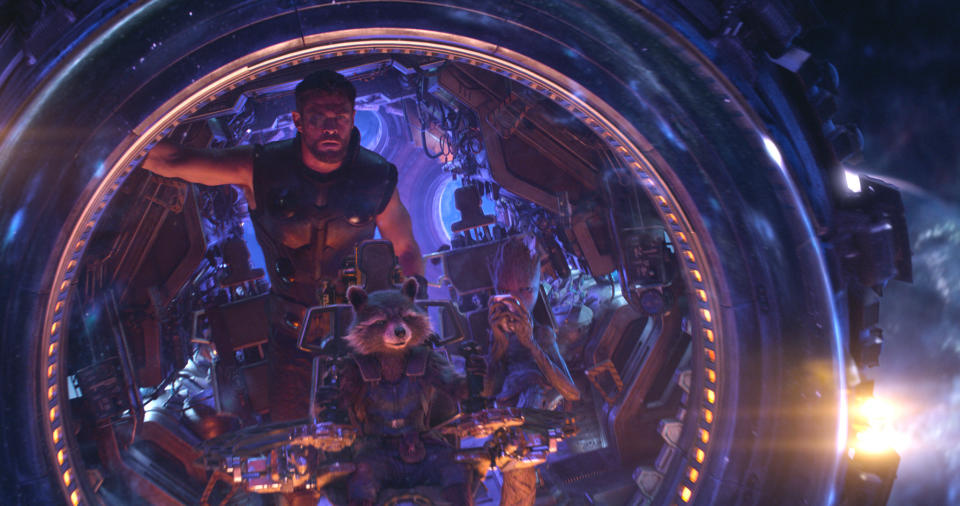 This image released by Marvel Studios shows Chris Hemsworth as Thor. with characters Rocket, voiced by Bradley Cooper, seated center, and Groot, voiced by Vin Diesel, in a scene from “Avengers: Infinity War.” (Marvel Studios via AP)