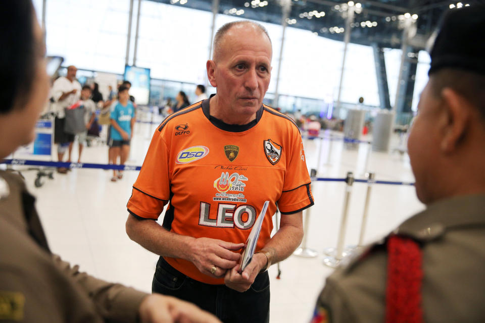 British caver Vern Unsworth speaks to police officers as he proceeds to a check-in counter at Bangkok’s International Airport, Thailand, July 19, 2018. REUTERS/Athit Perawongmetha