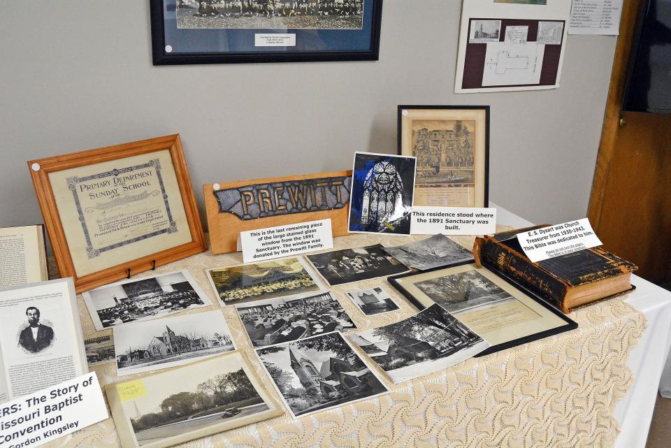 A table at First Baptist Church displays images and the history of its Georgian Gothic sanctuary from 1891 to 1955. All that is left of the church's physical presence is a small piece of a much larger stained-glass window, a brick and a few wooden flue pipes from that church's organ.