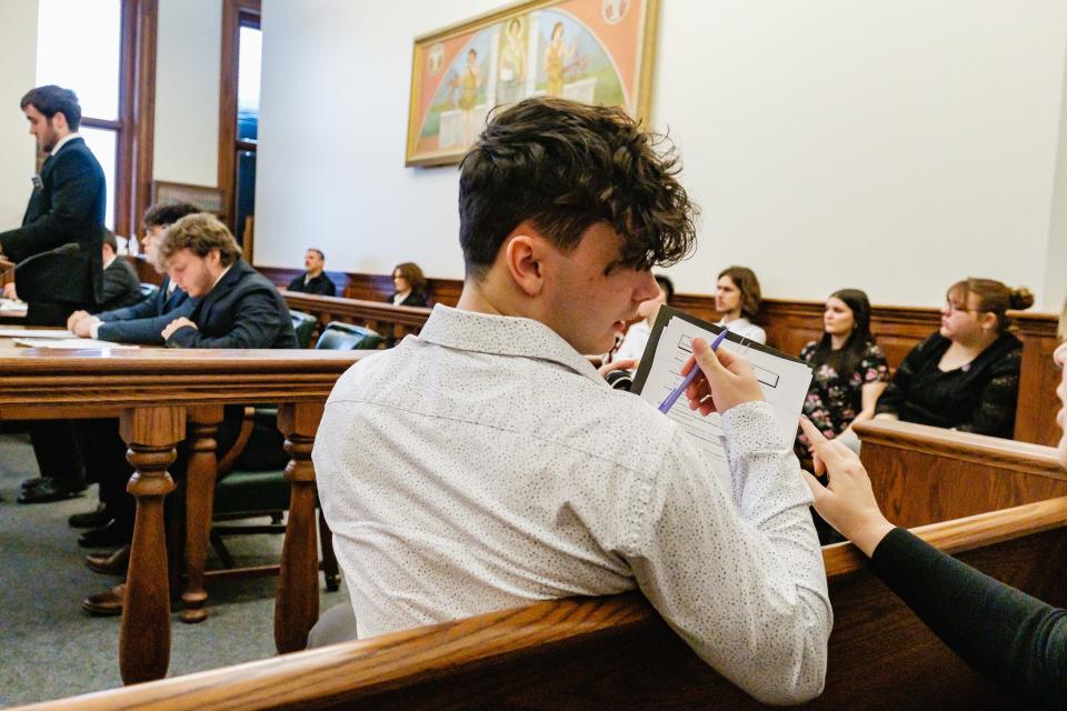 Morrison McBridge, a senior from New Philadelphia High School working as an official timer, confers with his adviser Steph Jenkins, right, during the regional competition of the 40th annual Ohio High School Mock Trial Competition recently held at the Tuscarawas County Courthouse. New Philadelphia competed against Steubenville.