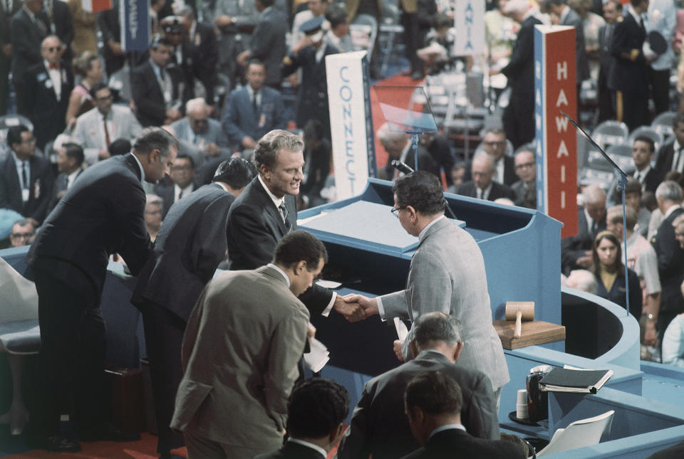 <p>The Rev. Billy Graham (center) is greeted on the podium of the 1968 Democratic National Convention in Chicago on Aug. 27, 1968. (Photo: AP) </p>