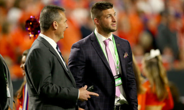 Urban Meyer talks with Tim Tebow during the 2016 College Football Playoff National Championship Game