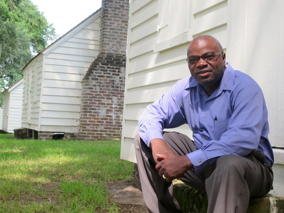 In this Aug. 14, 2013 photo. Joe McGill, who works with the National Trust For Historic Preservation, sits outside one of the slave cabins at McLeod Plantation in Charleston, S.C. As part of the Slave Dwelling Project, McGill has slept in old slave dwellings in a dozen states during the past three years to draw attention to the need to preserve the structures and tell their stories.(AP Photo/Bruce Smith, File)