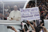 Pope Francis passes by a banner of a protester as he leaves after visiting St Mary's Pro-Cathedral, in Dublin, Ireland, Saturday, Aug. 25, 2018. Pope Francis is on a two-day visit to Ireland. (AP Photo/Matt Dunham)