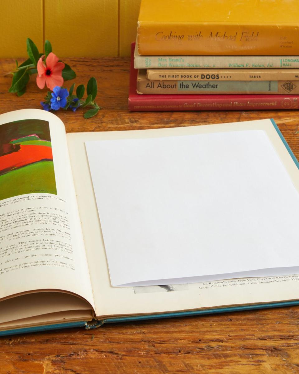 an open book with office paper on one page used in pressing flowers