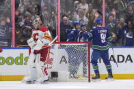 Calgary Flames goalie Jacob Markstrom, left, stands in front of the net as Vancouver Canucks' Elias Pettersson, Nils Hoglander and Nikita Zadorov, from left, celebrate Hoglander's goal during the first period of an NHL hockey game Tuesday, April 16, 2024, in Vancouver, British Columbia. (Darryl Dyck/The Canadian Press via AP)