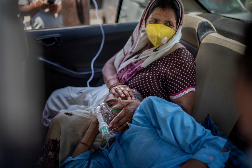 A patient breathes with the help of oxygen provided by a Gurdwara, Sikh place of worship, inside a car in New Delhi, India, Saturday, April 24, 2021. IndiaÕs medical oxygen shortage has become so dire that this gurdwara began offering free breathing sessions with shared tanks to COVID-19 patients waiting for a hospital bed. They arrive in their cars, on foot or in three-wheeled taxis, desperate for a mask and tube attached to the precious oxygen tanks outside the gurdwara in a neighborhood outside New Delhi.