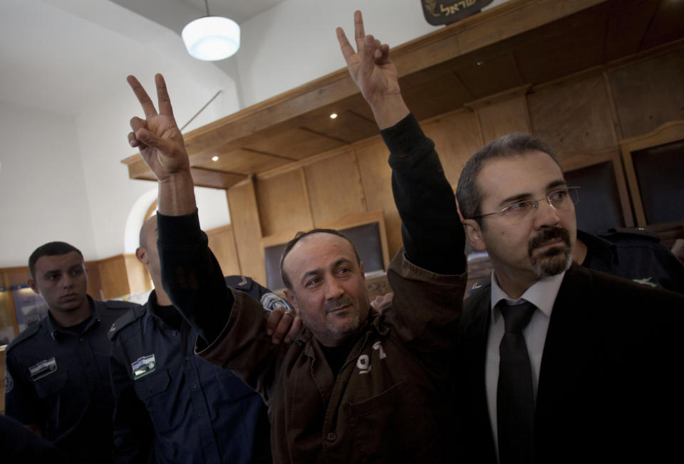 FILE - In this Jan. 25, 2012 file photo, senior Fatah leader Marwan Barghouti makes the victory sign in front of the media during his arrival to testify in a trial at a Jerusalem court. Hamas officials say that any cease-fire deal with Israel should include the release of prisoner Marwan Barghouti — a leader of the militant group's main political rival. The demand by Hamas marks the central role Barghouti plays in Palestinian politics — even after more than two decades behind bars and sentenced by Israel to multiple life terms in prison. (AP Photo/Bernat Armangue, File)