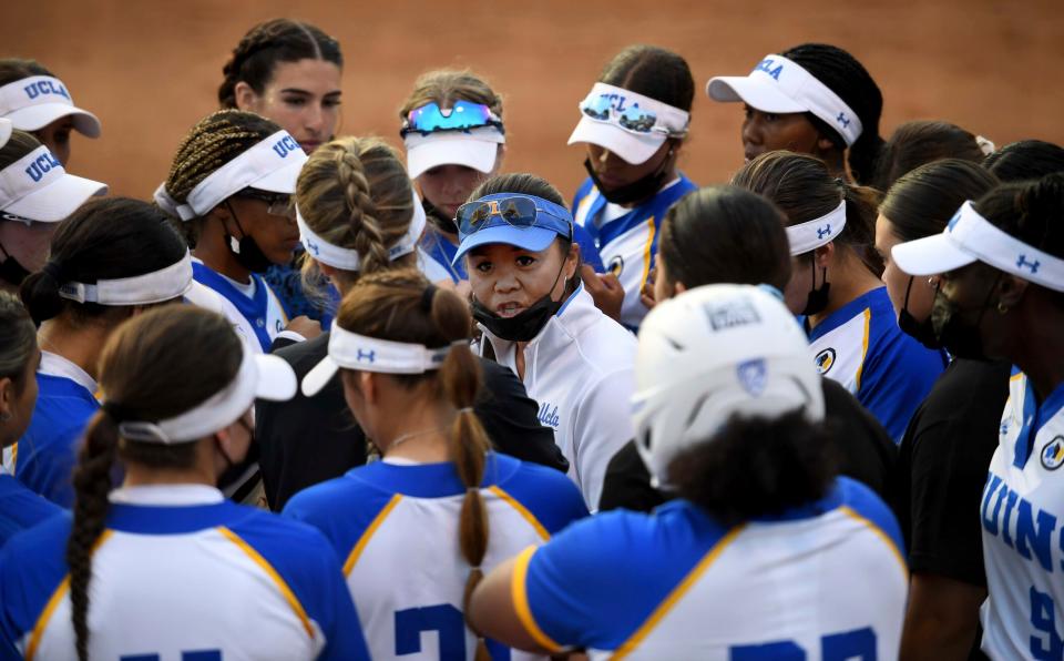 FILE - In this Friday, May 28, 2021, file photo, UCLA head coach Kelly Inouye-Perez, center, talks to her team in the second inning of Game 2 of NCAA college softball tournament super regional against the Virginia Tech at Easton Field on the campus of UCLA in Westwood, Calif. Top seed Oklahoma and 2019 national champion UCLA highlight the Women's College World Series field.(Keith Birmingham/The Orange County Register via AP, File)