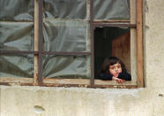 <p>A young girl peers out of a window covered in plastic in place of destroyed glass panes, in Gorazde, Bosnia, Jan. 19, 1996. Encircled by Bosnian Serb forces at the beginning of the war, Gorazde held on as the other eastern Bosnian Muslim enclaves fell. (Photo: Jacqueline Larma/AP) </p>