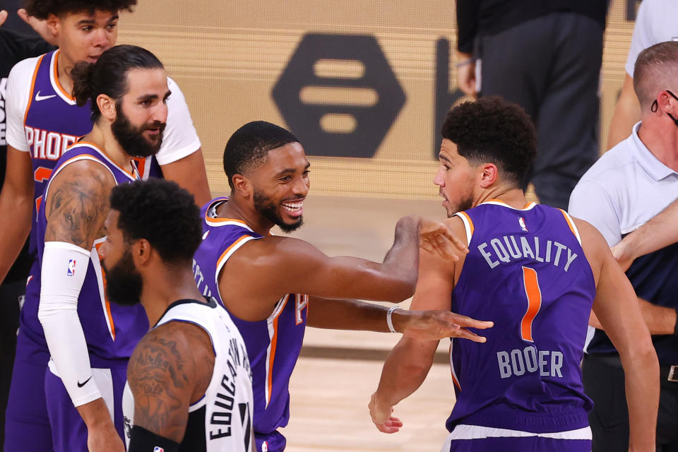 LAKE BUENA VISTA, FLORIDA - AUGUST 04: Devin Booker #1 of the Phoenix Suns celebrates with Mikal Bridges #25 after scoring the game winning basket against the LA Clippers  at The Arena at ESPN Wide World Of Sports Complex on August 04, 2020 in Lake Buena Vista, Florida. NOTE TO USER: User expressly acknowledges and agrees that, by downloading and or using this photograph, User is consenting to the terms and conditions of the Getty Images License Agreement.  (Photo by Kevin C. Cox/Getty Images)