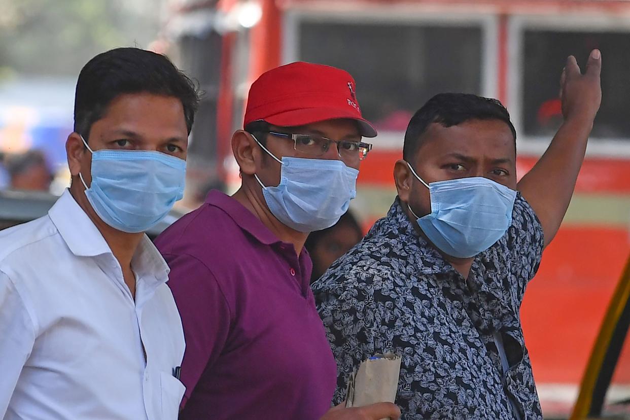 Men wearing facemasks amid concerns of the spread of the COVID-19 coronavirus stand outside a hospital, in Mumbai on March 12, 2020. (Photo by Indranil MUKHERJEE / AFP) (Photo by INDRANIL MUKHERJEE/AFP via Getty Images)