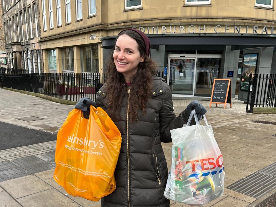 Insider reporter holding a Tesco and a Sainbury's bag