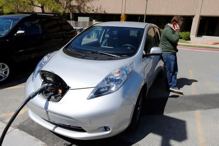 Justin Miller makes a phone call as he charges his 2013 Nissan Leaf electric car at ABB Inc.'s DC fast charging station in Salt Lake City, Utah, in this April 30, 2014 file photo. REUTERS/George Frey/Files