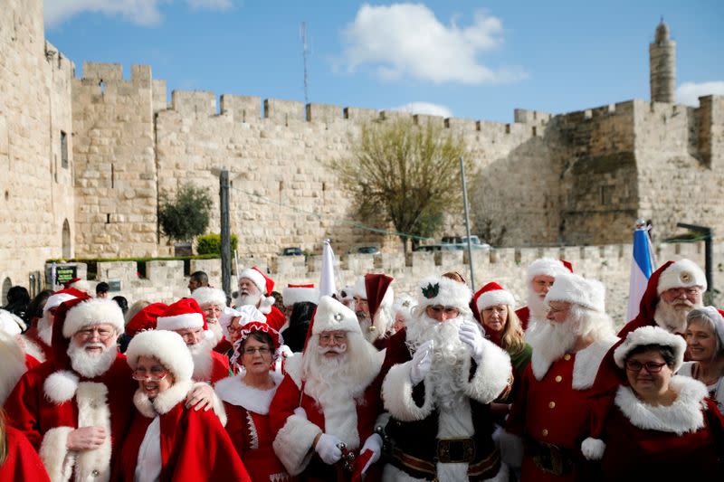 A group of Santa Clauses from around the world, gather together for a group photograph upon their arrival into Jerusalem's Old City