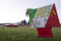 A sign advertising pizza is posted outside a home in Scottsdale, Ariz. on April 3, 2021. Beaten down by the pandemic, some laid-off or idle restaurant workers have pivoted to dishing out food from home. (AP Photo/Ross D. Franklin)